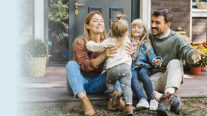 Couple playing with thier kids outside home